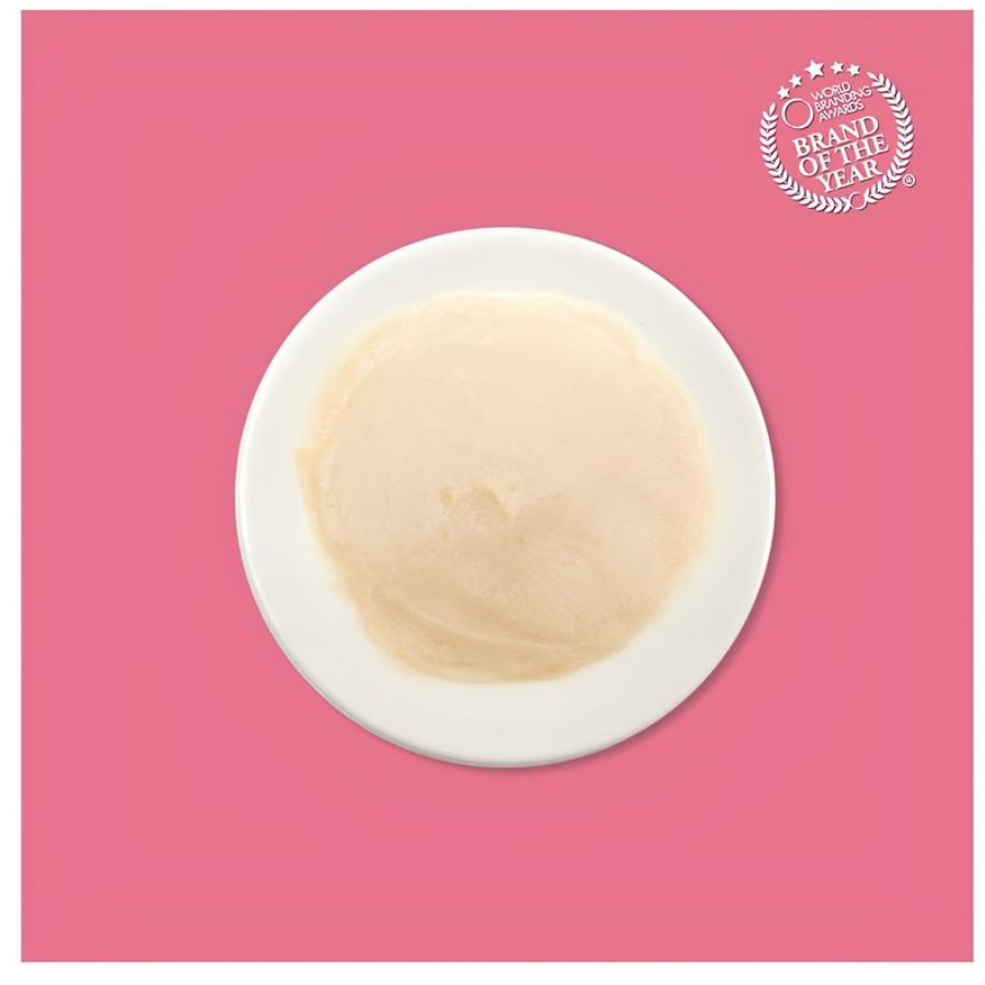 Textura cremosa del puré de atún y salmón Kit Cat Purr Puree servida en un plato blanco