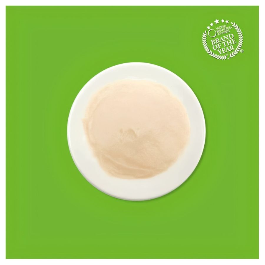 Textura cremosa del puré de pollo con colágeno Kit Cat Purr Puree Plus servida en un plato blanco
